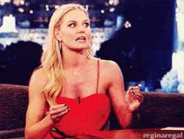 a woman in a red dress is sitting at a table with reginaregal written on the bottom right corner
