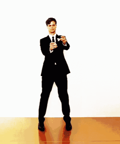 a man in a suit and tie is dancing with a flame coming out of his tie