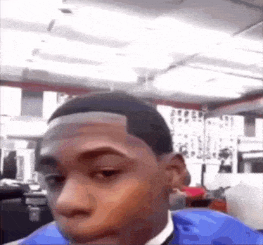 a man is getting his hair cut in a barber shop .