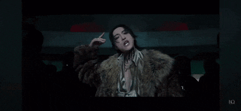 a woman is wearing a fur coat and making a funny face