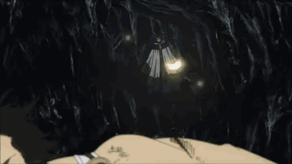 a man is laying down in a dark cave with a light shining on him