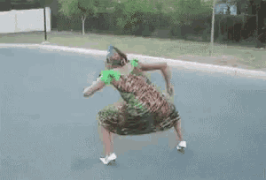 a woman in a dress is riding a skateboard down the street .