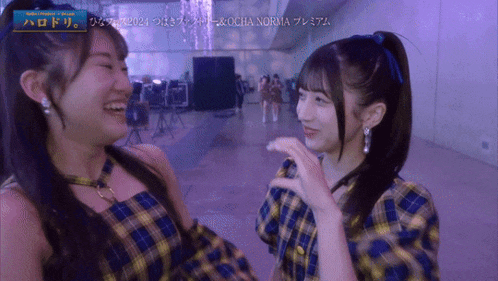 two girls are standing next to each other and one has a sign that says ocha norma on it