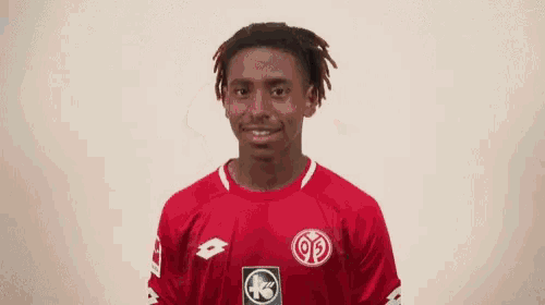 a young man wearing a red lotto jersey smiles