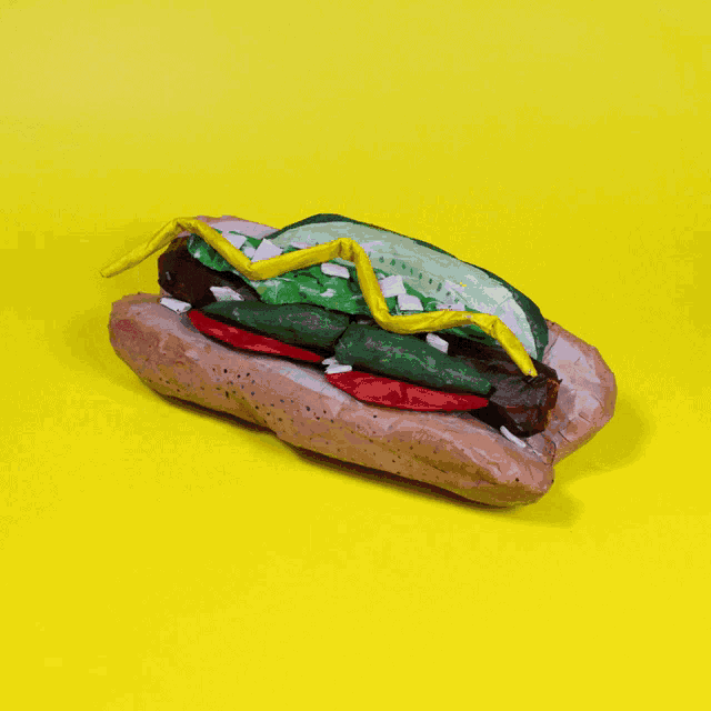 a sculpture of a hot dog on a yellow background