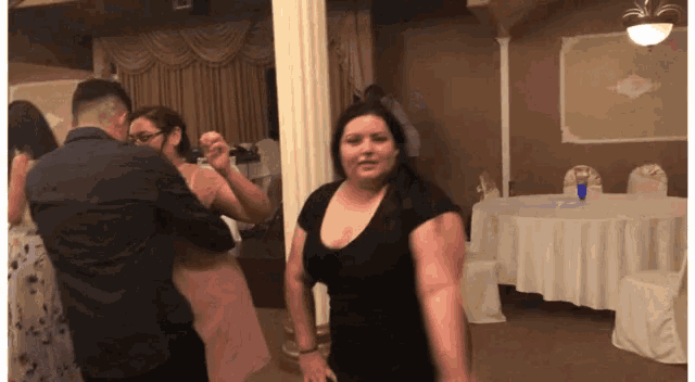 a woman in a black dress is dancing with a man