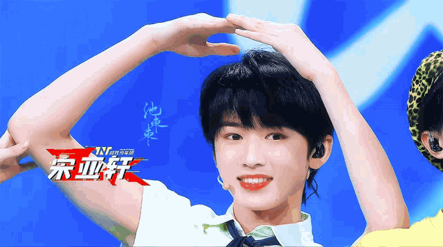 a person with chinese writing on their arm stands in front of a blue background