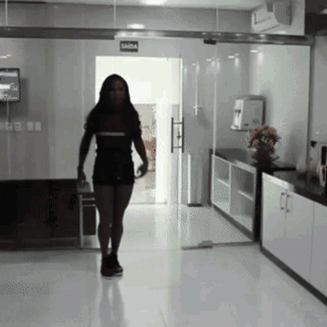 a woman walking in a hallway with a sign that says saida
