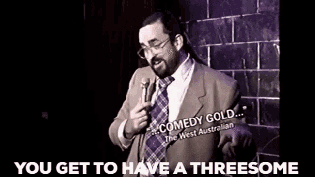 a man in a suit and tie is holding a microphone and saying you get to have a threesome