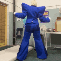 a man in a blue suit stands in a room