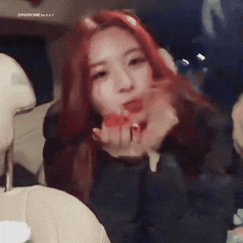 a woman with red hair is blowing a kiss in a car with the words syndrome for r & y on the bottom