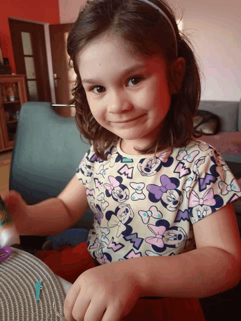 a little girl is wearing a minnie mouse shirt