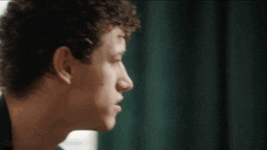 a close up of a young man 's face looking out a window .