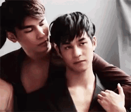 two men are hugging each other and one of them is kissing the other 's neck .