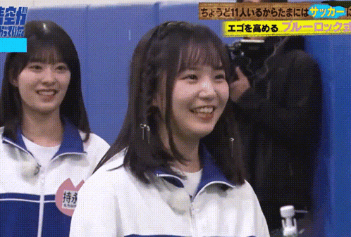 two girls are smiling in front of a sign that says " ego "