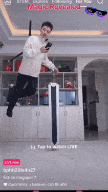a man is jumping in the air while holding a sword and looking at his cell phone