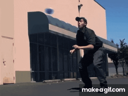 a man standing in front of a building with make a gif.com on the bottom of the screen