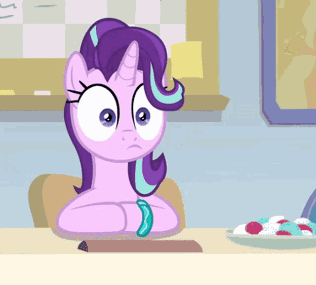 a cartoon pony is sitting at a table with a plate of candy