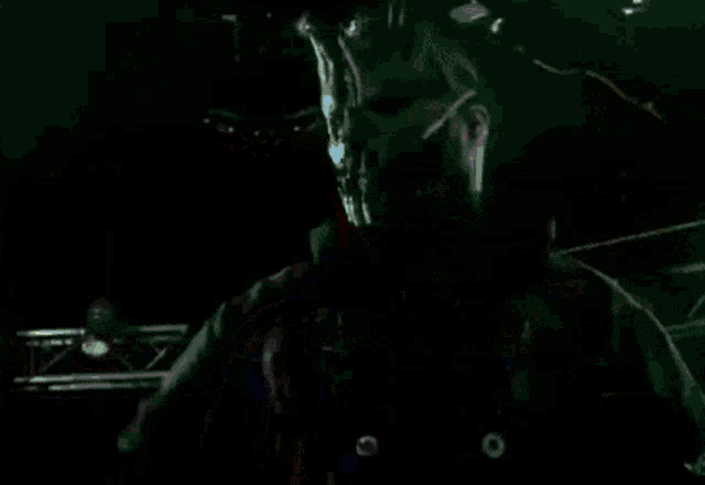 a group of people are standing in a dark room with their hands up in the air .