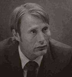 a black and white photo of a man wearing a suit and tie .
