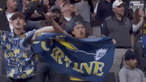 a man holds up a blue banner that says curry ine