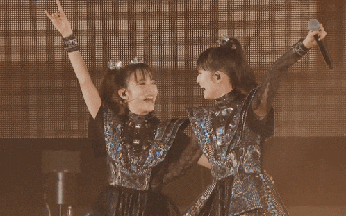 a couple of girls with their arms in the air
