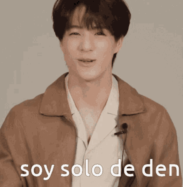 a man wearing a brown jacket with the words soy solo de den on the bottom