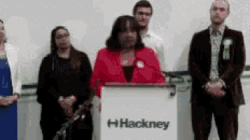 a group of people standing around a podium with the word hackney on it