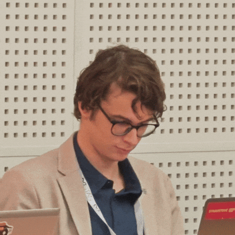 a man wearing glasses has a lanyard around his neck that says ' nvc ' on it