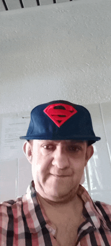 a man wearing a blue hat with a superman logo on it