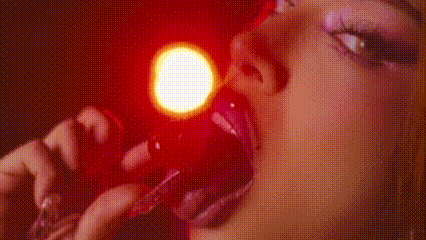 a close up of a woman 's mouth with a red light behind her .