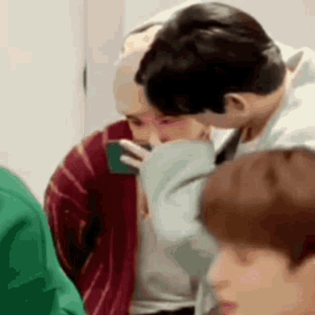 a man is kissing another man on the cheek .