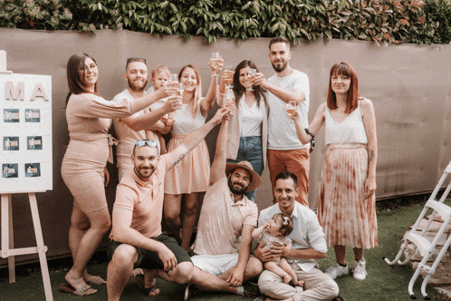 a group of people toasting with champagne in front of a sign that says mama
