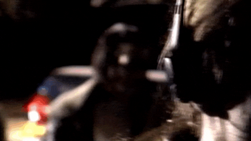 a blurry picture of a person holding a gun in the dark .