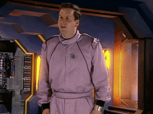 a man in a purple suit has a sticker on his chest that says ' ii ' on it