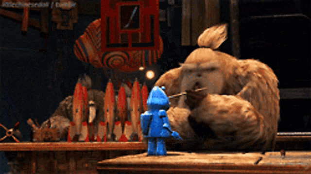 a blue robot is standing in front of a giant monster