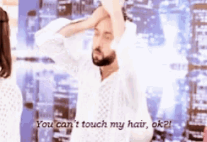 a man with a beard holds his hand to his head and says you can 't touch my hair ok ?