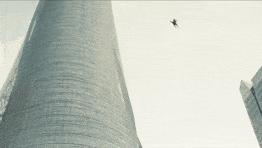 a person is flying through the air near a tall building