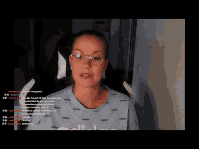 a woman wearing glasses and a blue adidas shirt