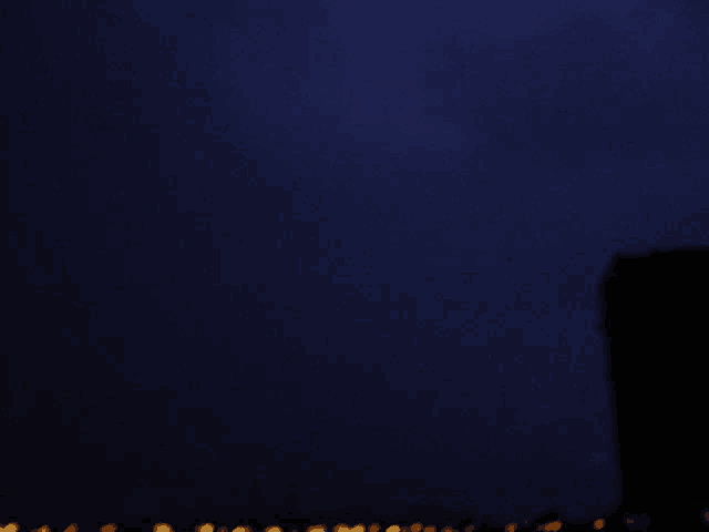 a dark blue background with a few lights visible