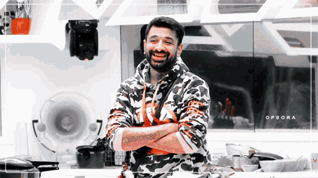 a man with a tattoo on his arm is smiling in a kitchen