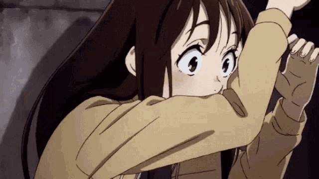 a close up of a girl with long hair covering her face with her hand .