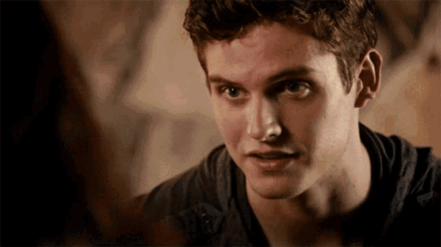 a close up of a young man 's face looking at someone