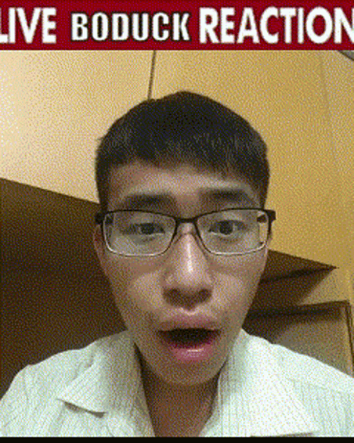 a man wearing glasses is making a funny face in front of a sign that says live boduck reaction