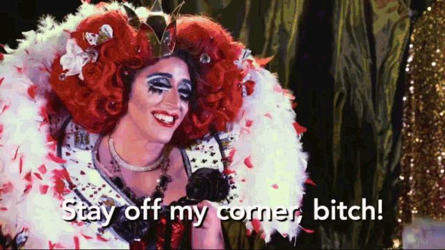 a drag queen says " stay off my corner bitch " while wearing a red wig