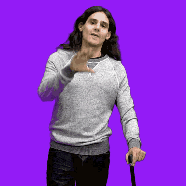 a man in a grey sweater is surrounded by red hearts on a purple background