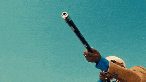 a man in a tan suit is holding a shotgun in his right hand