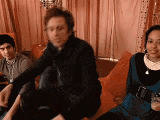 a group of people are sitting on a couch in a living room .