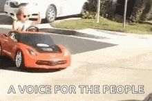 a man is driving a toy car on a street .