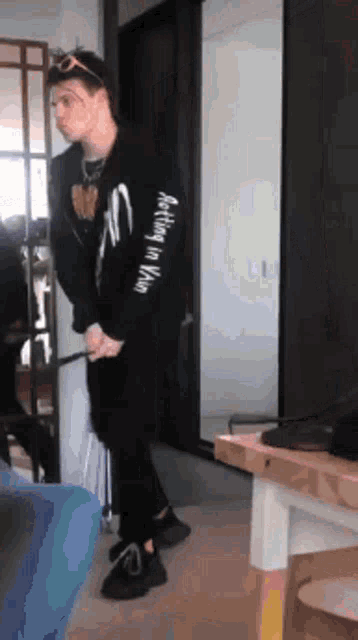 a man wearing a black shirt that says nothing in vain is standing in front of a mirror .